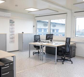 Bürocontainer mit zwei Schreibtischen in der Innenansicht