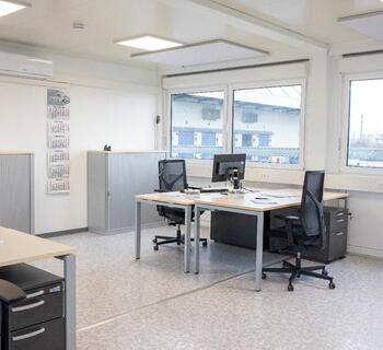 Bürocontainer von innen mit 2 Tischen