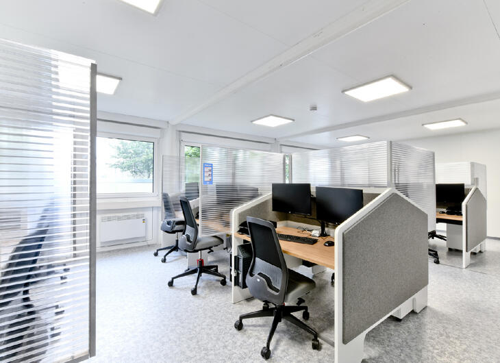 Bürocontainer von innen mit ausgestatteten Tischen und Trennwänden Bürocontainer von innen mit ausgestatteten Tischen und Trennwänden