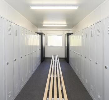 Umkleidecontainer von innen mit Bank in der Mitte und rechts links Spinde