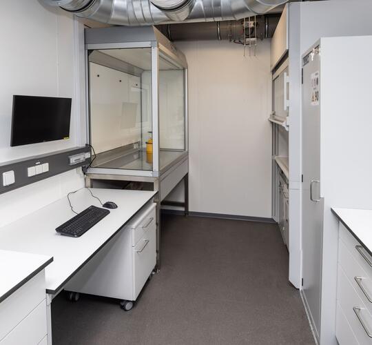 Innenansicht eines Laborcontainers mit Schutzausrüstung