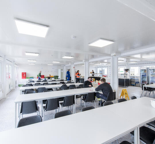 Aufenthaltscontainer von innen mit mehreren Tischen