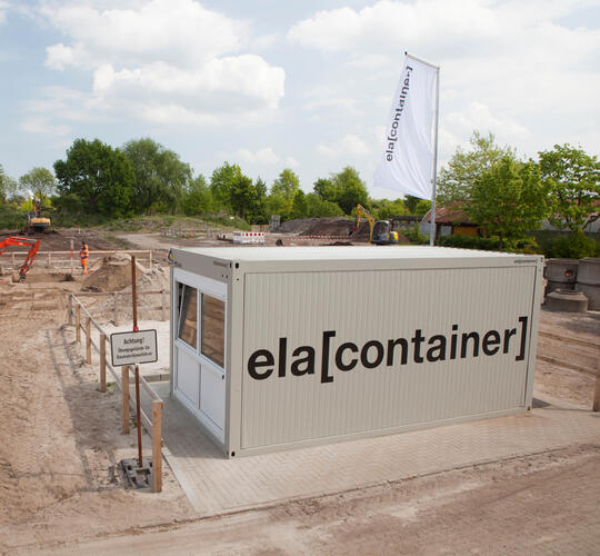 Außenansicht einzelner Baucontainer auf Baustelle mit Logo von ELA Container