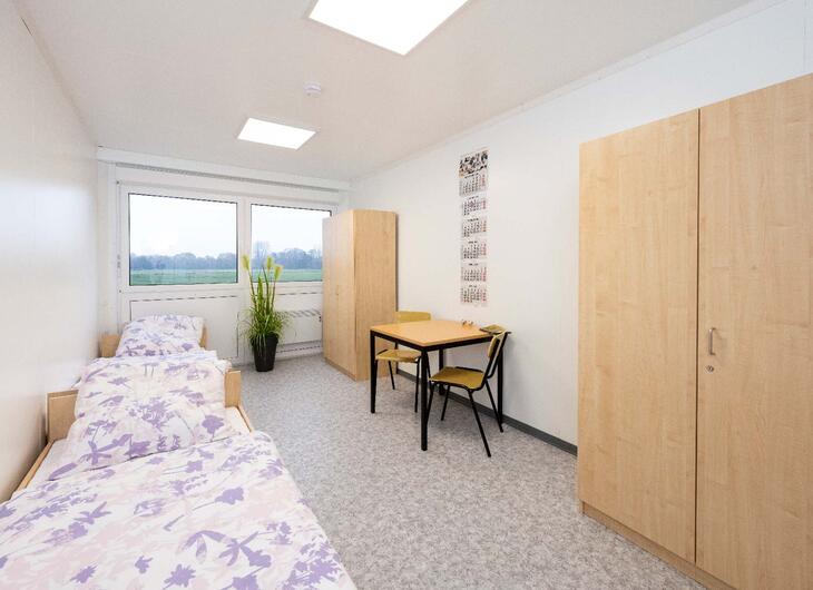 Wohncontainer innen mit Bett, Tisch und Schrank