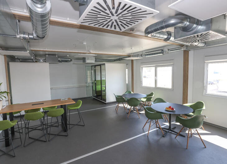 Aufenthaltsraum innen mit grünen Stühlen