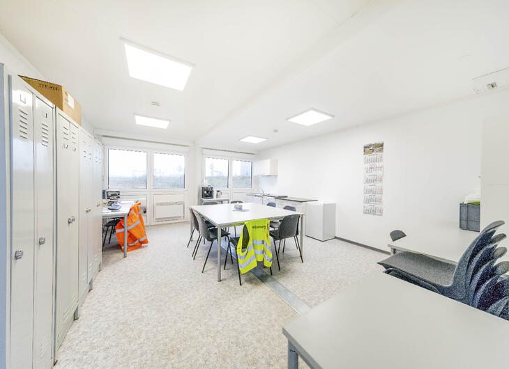 Aufenthaltsraum mit Spinden, Tisch und Küche