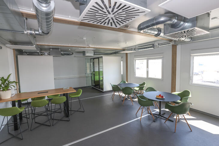 Aufenthaltsraum innen mit grünen Stühlen