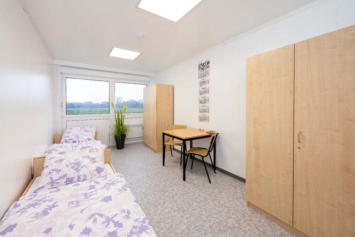 Wohncontainer mit zwei Betten, Schreibtisch und Schränken