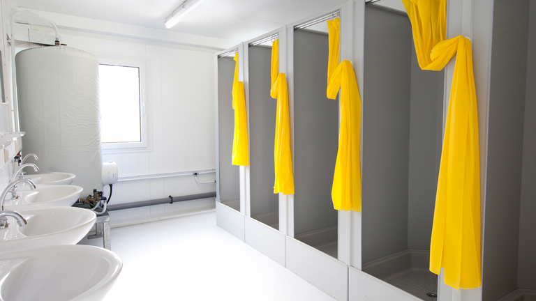 Duschcontainer mit mehreren Duschen und Waschbecken