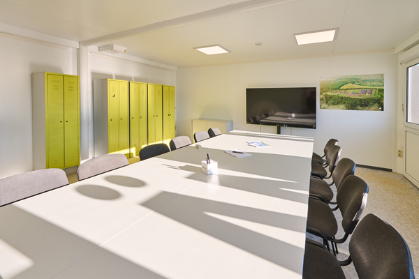 Lyst mødelokale med gule skabe