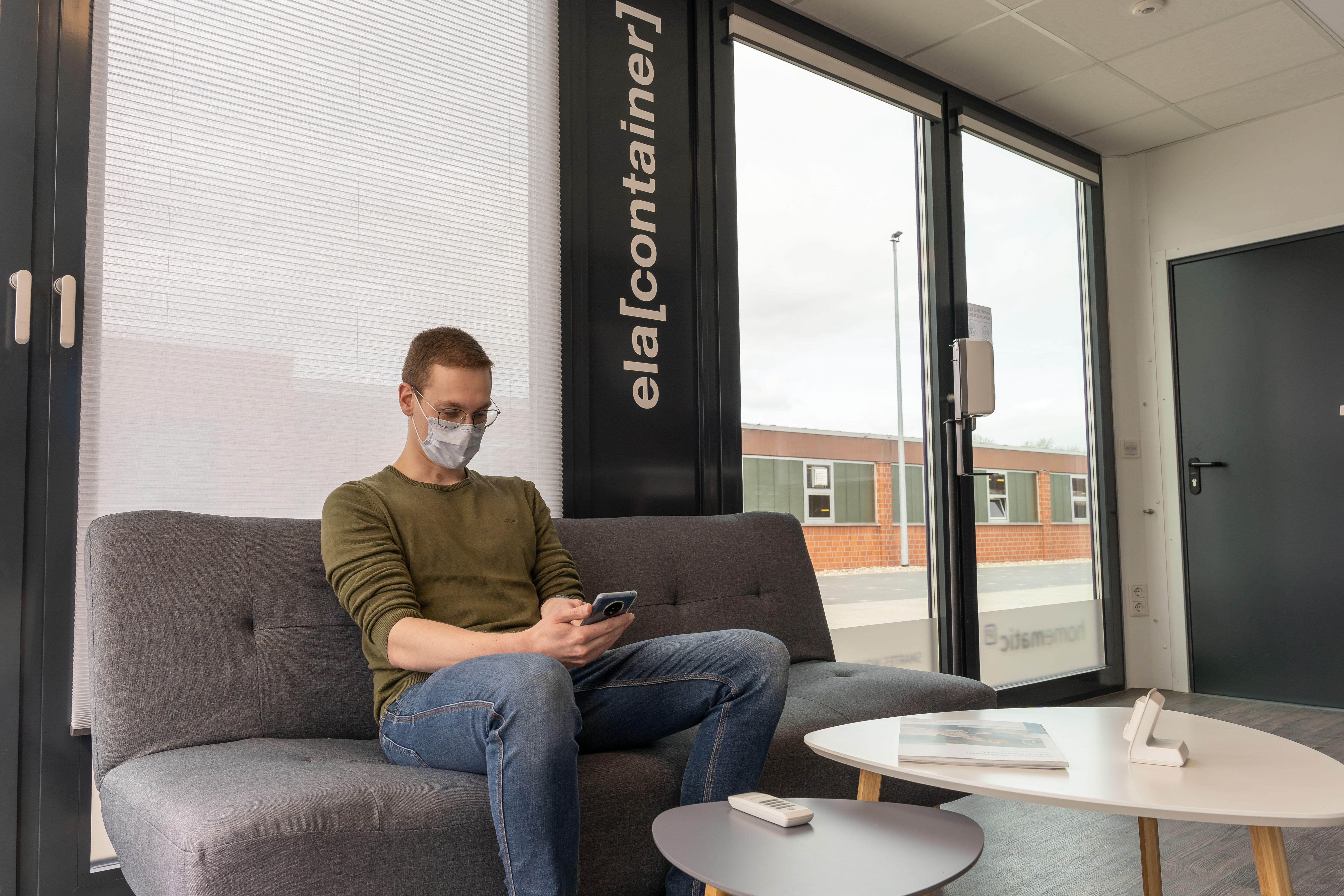 Mand med mobiltelefon siddende i udstillingsmodulet