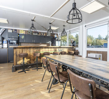 Moderne indrettet spiseområde med bardisk og langbord
