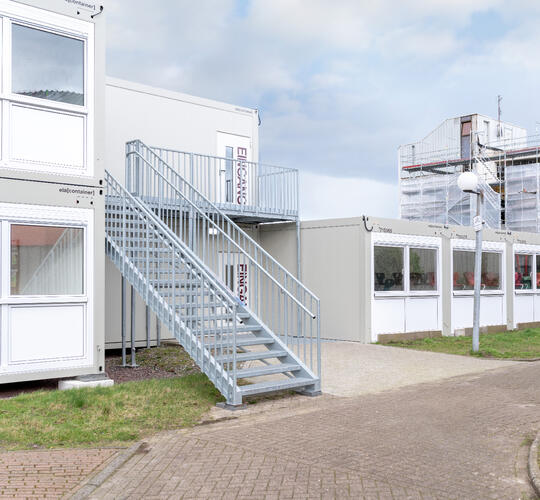 Udvendig side af en modulskole med udvendig trappe til første sal