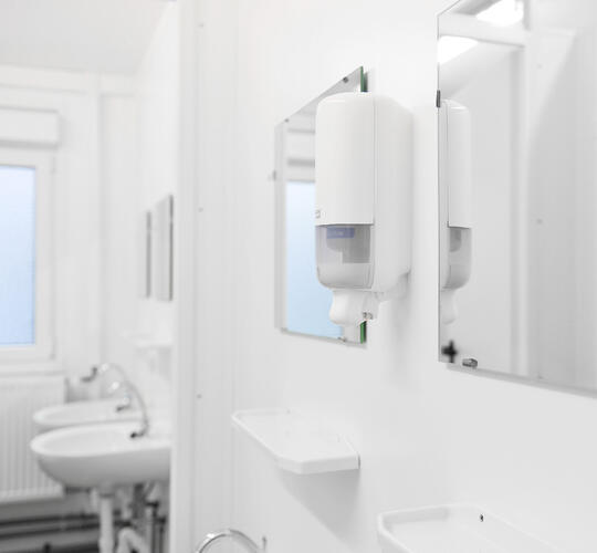 Indersiden af en sanitetsmodul med spejle og håndvaske