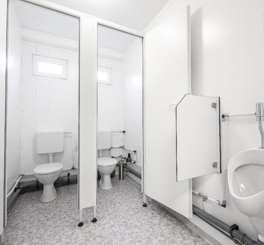 Sanitetsmodul med to toiletbåse og en urinal
