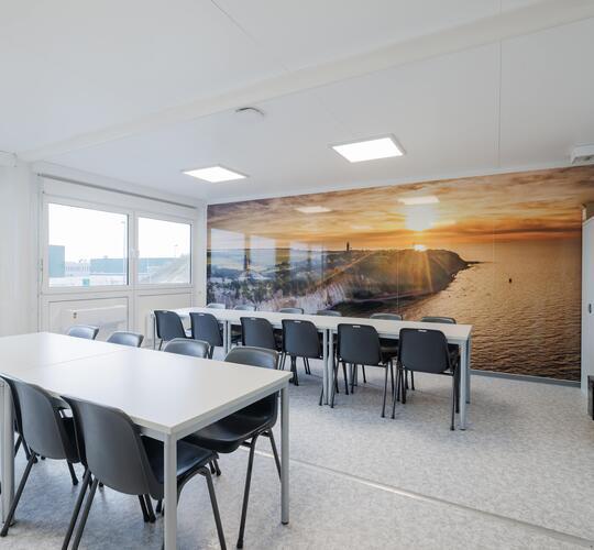 Indersiden af en opholdsmodul med borde og stole