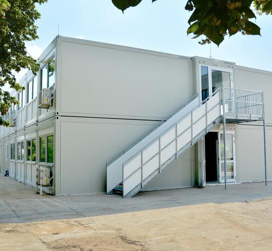 Lysegrå modulskole i to etager