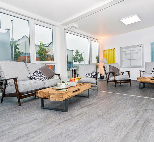 Loungecontainere med store glaspartier og stilfulde gulve