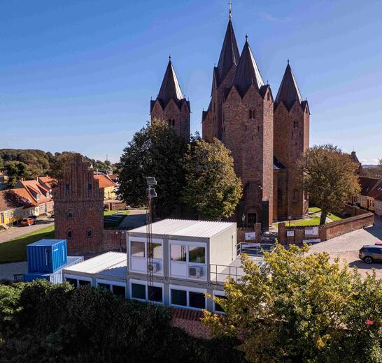 Lysegrå moduler foran en kirke