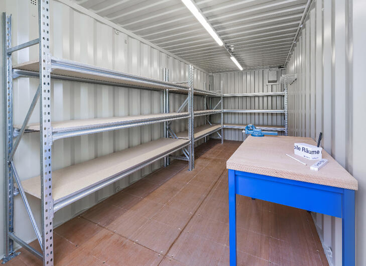 Indersiden af en lagercontainer med hylder og arbejdsbænk