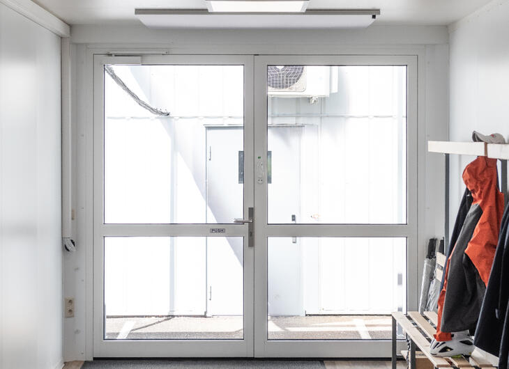 Indgangsområde med store glasdøre og plads til overtøj
