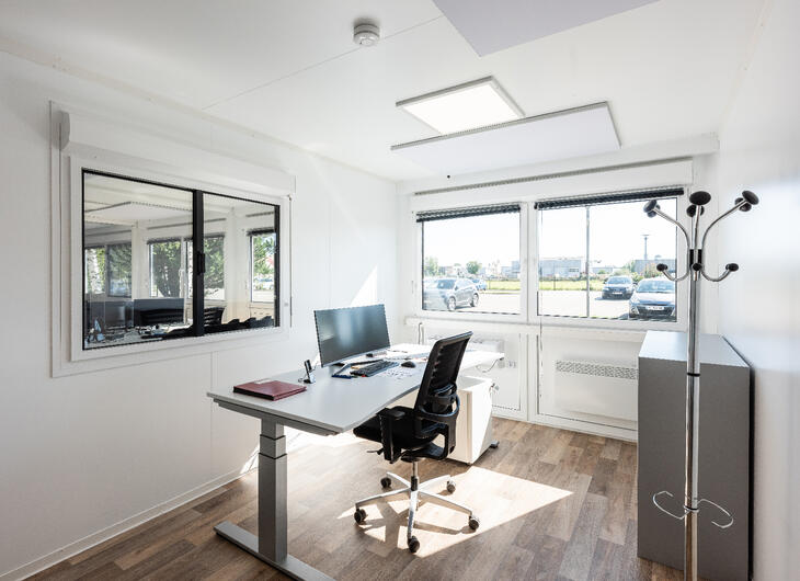 Enkelt arbejdsrum med vindue ind til de øvrige arbejdspladser