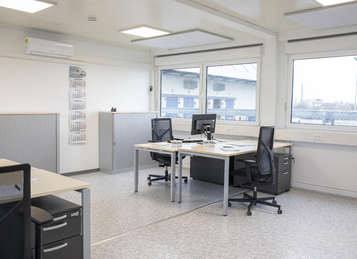 Arbejdsrum med flere arbejdspladser bestående af skriveborde og stole