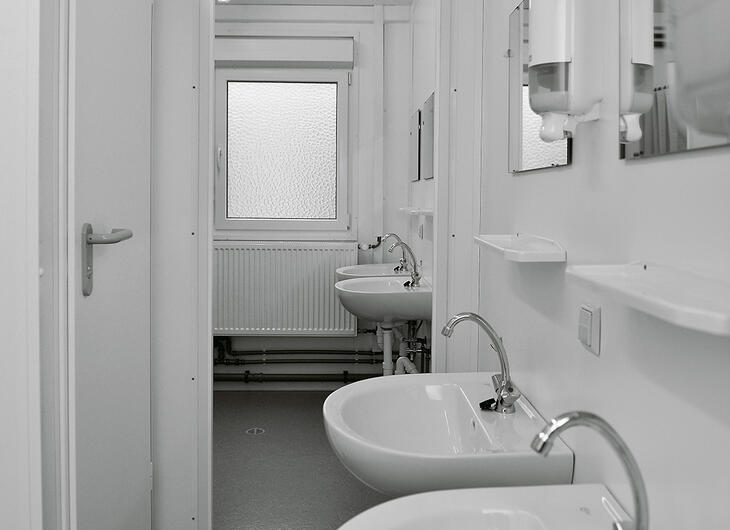 Sanitetsmodul med toiletbås, håndvask, spejle og sæbedispenser