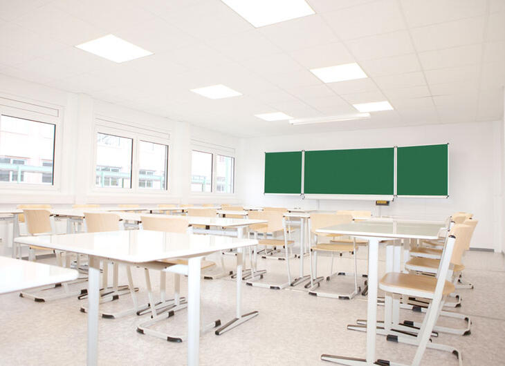 Lyst klasselokale med borde og stole