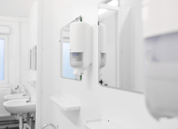 Indersiden af en sanitetsmodul med spejle og håndvaske