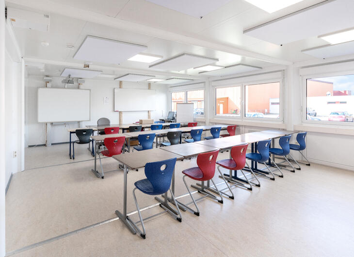 Klasselokale med røde og blå stole