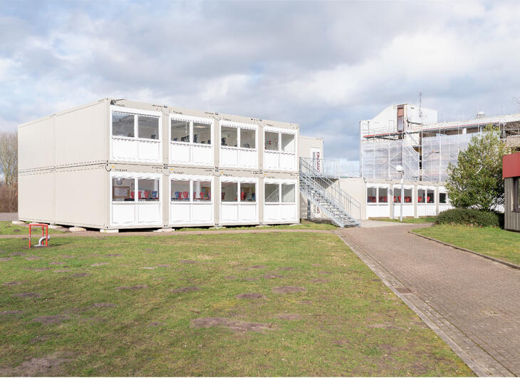 Stor skolebygning i et og to plan med udvendig trappe