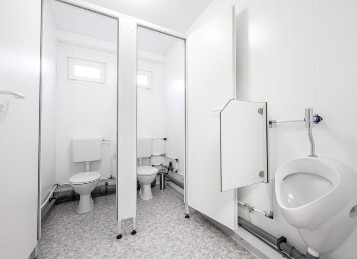 Toiletkabine og separat urinal