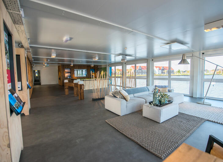 Loungecontainer med sofaer og store glaspartier