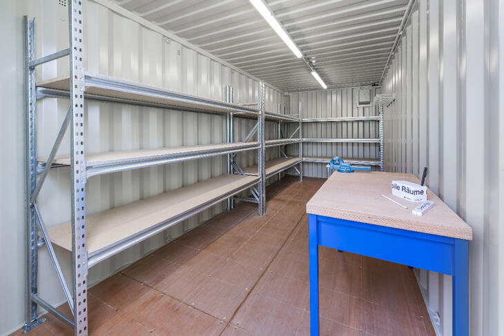 Indersiden af en lagercontainer med hylder og arbejdsbænk