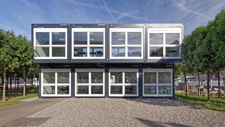 To etager med kontorer og mødelokaler i antracitfarve