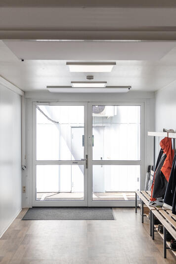 Indgangsområde med store glasdøre og plads til overtøj