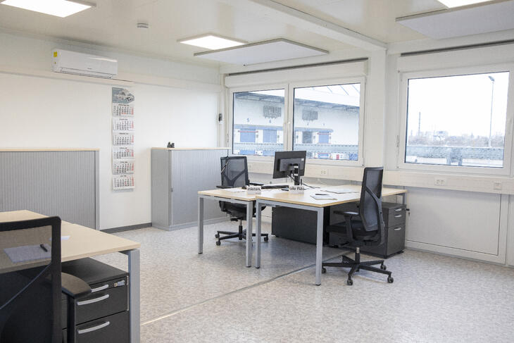 Arbejdsrum med flere arbejdspladser bestående af skriveborde og stole