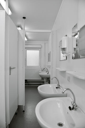 Sanitetsmodul med toiletbås, håndvask, spejle og sæbedispenser