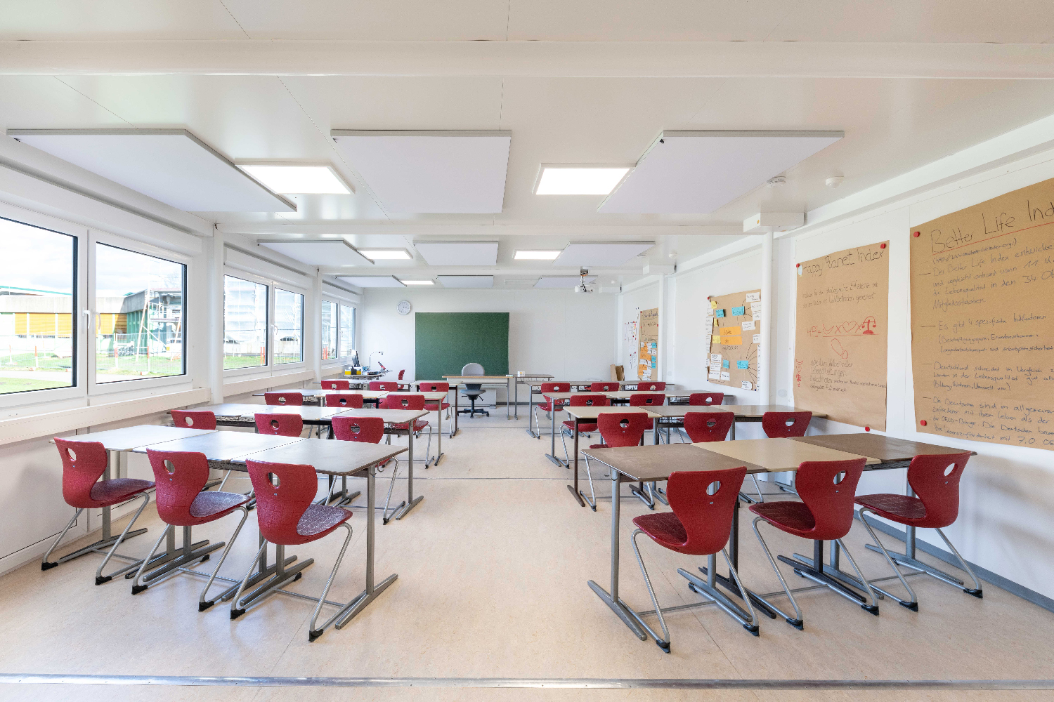 Stort klassrum med bord och röda stolar Stort klassrum med bord och röda stolar