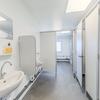 Sanitetsutrymmen med tvättställ och toalettbås