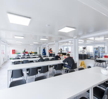 Stor personalmatsal med bord och stolar