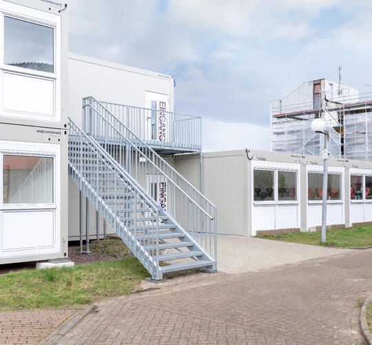 Utsida av en modulskola med utvändig trappa upp till andra våningen