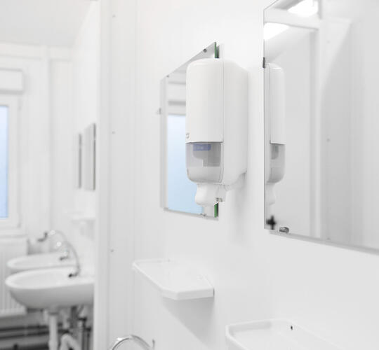 Insidan av en sanitetsmodul med speglar och handfat