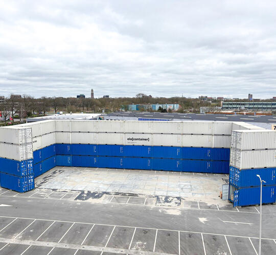 Containervägg bestående av vita och blå staplade containrar