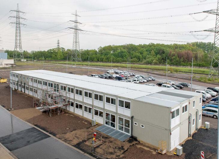 Stor modulanläggning med entrédel och parkeringsplats