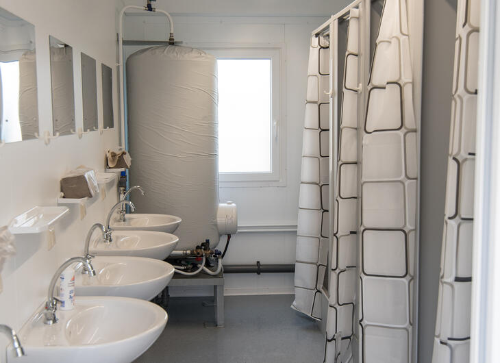 Sanitetsmodul med handfat och duschbås med draperi