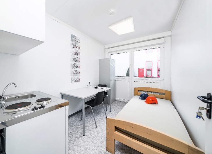 Insidan på en bostadsmodul med säng, bord, stolar