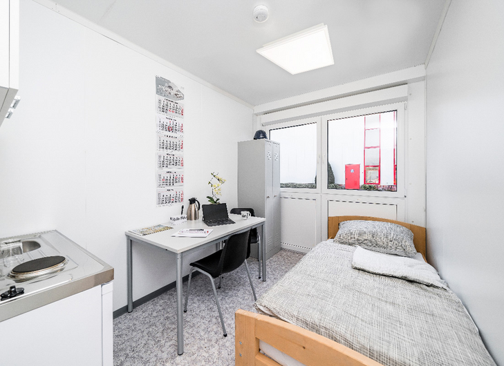 Bostadsmodul med pentry, säng, skåp, bord och stolar