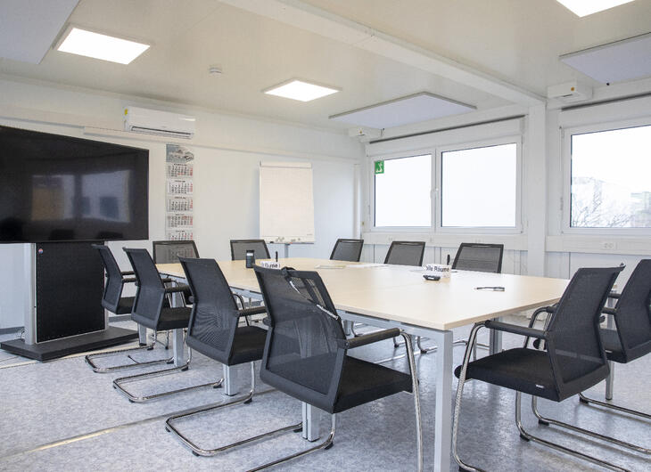 Mötesrum med bord, stolar och tv-skärm Mötesrum med bord, stolar och tv-skärm